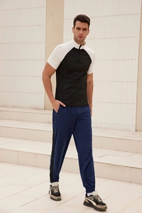 Detail of men's loose sports trousers with side button snaps and stripe accents