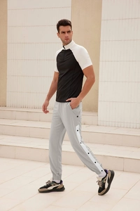 Men's loose track pants featuring white side stripes and snap button details on light grey fabric