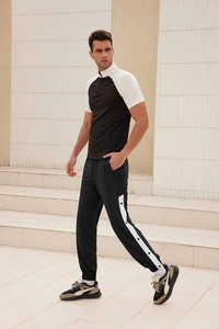 Detail shot of men's athletic jogger pants with side buttons and white stripe accents
