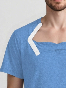 Detail of light blue adaptive surgery shirt showing side snap buttons and fabric texture