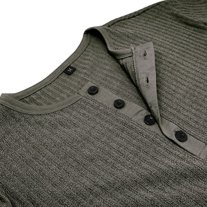 Gros plan du col de chemise Henley en maille gaufrée vert olive avec quatre boutons noirs