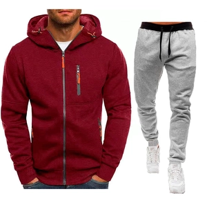 Dettaglio della felpa bordeaux con zip e pantaloni sportivi grigi con accenti arancioni