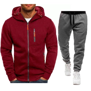 Dettaglio della felpa con cappuccio bordeaux con accenti arancioni e pantaloni grigi