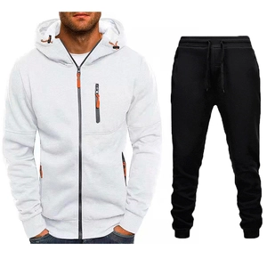 Dettaglio della felpa bianca con zip arancioni e pantaloni sportivi neri coordinati