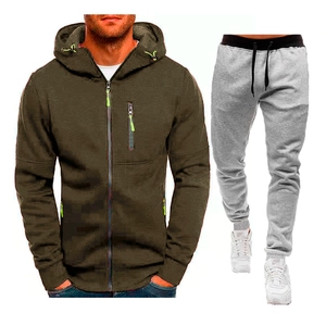Dettaglio della felpa con cappuccio verde oliva e dei pantaloni sportivi grigi con coulisse