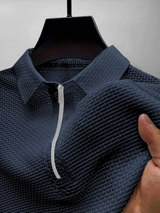 Gros plan du tissu en maille extensible et de la fermeture éclair sur le polo bleu marine