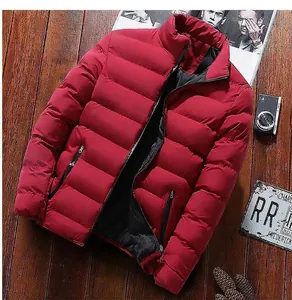 Détail d'une doudoune rouge matelassée avec poches zippées sur un fond en bois sombre