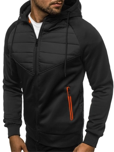 Detail of men's black zip-up hoodie featuring orange zipper and quilted chest panel