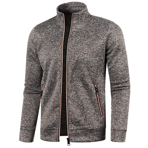 Detail of grey knitted jacket with contrast orange zippers and functional pockets