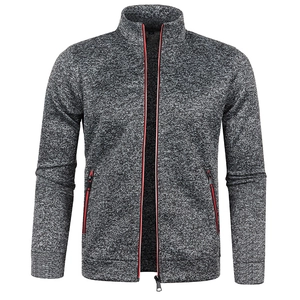 Detail of dark grey knit jacket showing striking red trim on high-quality zippers