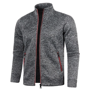 Detail of men's knit sweater featuring zipper pockets and contrast red trimming edge
