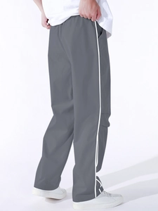 Detail view of men's grey cargo pants with white side stripes and elastic waist