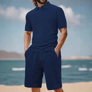 Men's navy blue jacquard polo and shorts set with herringbone texture on a sunny beach
