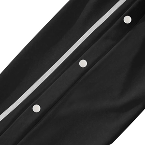Macro shot of black joggers with three white snap buttons and side stripe detail