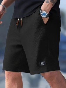 Detailed macro view of waffle knit fabric and drawstring waist on black casual shorts