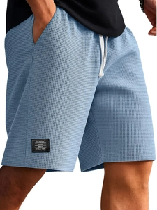 Dettaglio del tessuto a nido d'ape azzurro dei pantaloncini con coulisse e etichetta