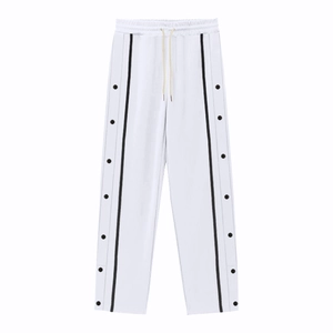 Détail du jogging blanc avec bande contrastée et boutons-pression en métal noir latérale