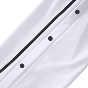 Détail du jogging blanc avec boutons-pression noirs et garniture de bande contrastée noire