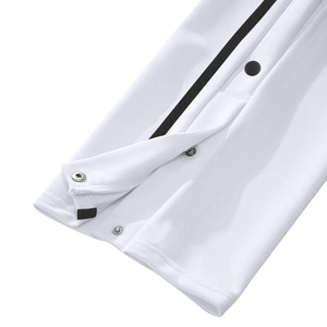 Gros plan du jogging blanc avec bandes latérales noires et boutons-pression métalliques