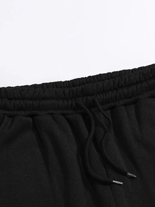 Detail of elastic waistband on black sports pants with metallic drawstring tips