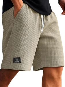 Dettaglio della trama a nido d'ape beige sui pantaloncini sportivi da uomo con coulisse
