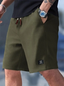 Close-up of olive green waffle knit shorts featuring texture and drawstring waist details