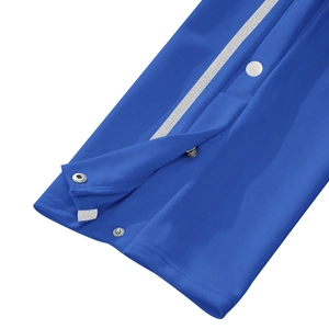 Detail of bright blue men's track pants with side stripes and silver snap buttons