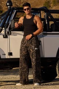Dettaglio del motivo mimetico digitale e logo del marchio sui pantaloni casual a gamba dritta