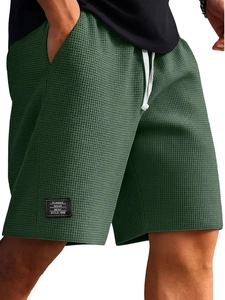 Vista dettagliata del tessuto a nido d'ape verde scuro e coulisse bianca per pantaloncini