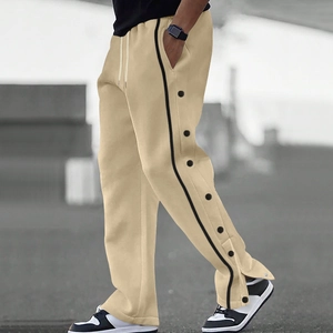 Détail du jogging beige pour homme avec boutons-pression latéraux et bandes noires