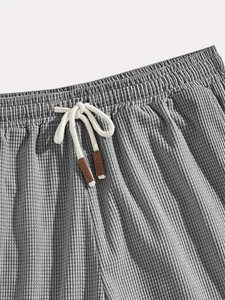 Detail view of gray waffle corduroy shorts with elastic waistband and white drawstrings