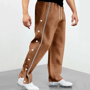 Detail view of brown jogger pants featuring side metal snap buttons and grey side stripes