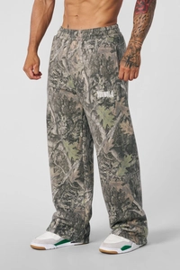 Dettaglio dei pantaloni sportivi mimetici larghi con elastico in vita e stampa logo