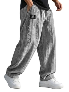 Detail view of gray jacquard knit pants featuring vertical stripes and side pocket patch