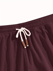 Detailed close-up of burgundy waffle knit texture shorts with elastic drawstring waist