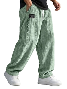 Detailed view of sage green knitted pants with textured 3D jacquard stripes and drawstring