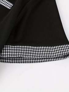 Dettaglio della polo nera con elegante bordo a motivo pied de poule sulla cucitura
