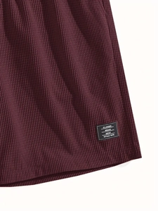 Close-up of burgundy waffle knit fabric texture and classic wear brand label detail