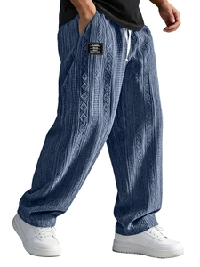 Detail of navy blue knit trousers featuring textured cable patterns and a white drawstring