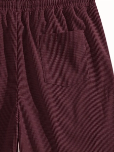 Detail of burgundy corduroy shorts with elastic waistband and back pocket texture
