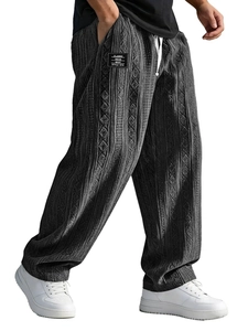Detail of grey jacquard knit trousers showing vertical texture and white drawstring waist