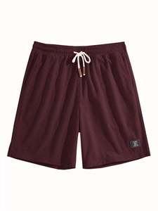 Flat lay of dark red waffle knit shorts featuring elastic waistband and white drawstrings