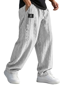 Detail of grey jacquard knit pattern on men's relaxed trousers with black brand label