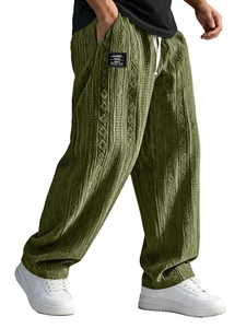 Macro view of green textured knit pants featuring a white drawstring and classic label