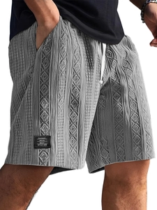 Detailed close-up of grey cable knit shorts featuring textured fabric and white drawstrings