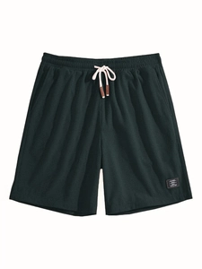 Detail shot of men's dark green waffle knit shorts featuring elastic waist and retro label