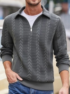 Dettaglio di un maglione da uomo grigio scuro con trama a treccia e colletto a mezza zip