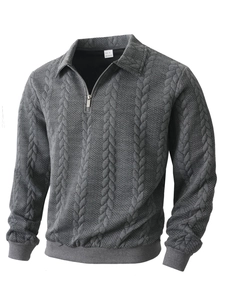 Détail de la texture en maille jacquard grise et du col polo avec demi-zip sur le pull