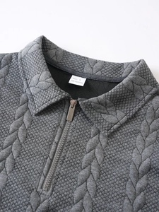 Close-up of grey jacquard knit fabric texture and silver half-zip collar detail