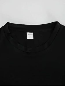 Close-up of the reinforced neckline and size label on a black men's cotton T-shirt